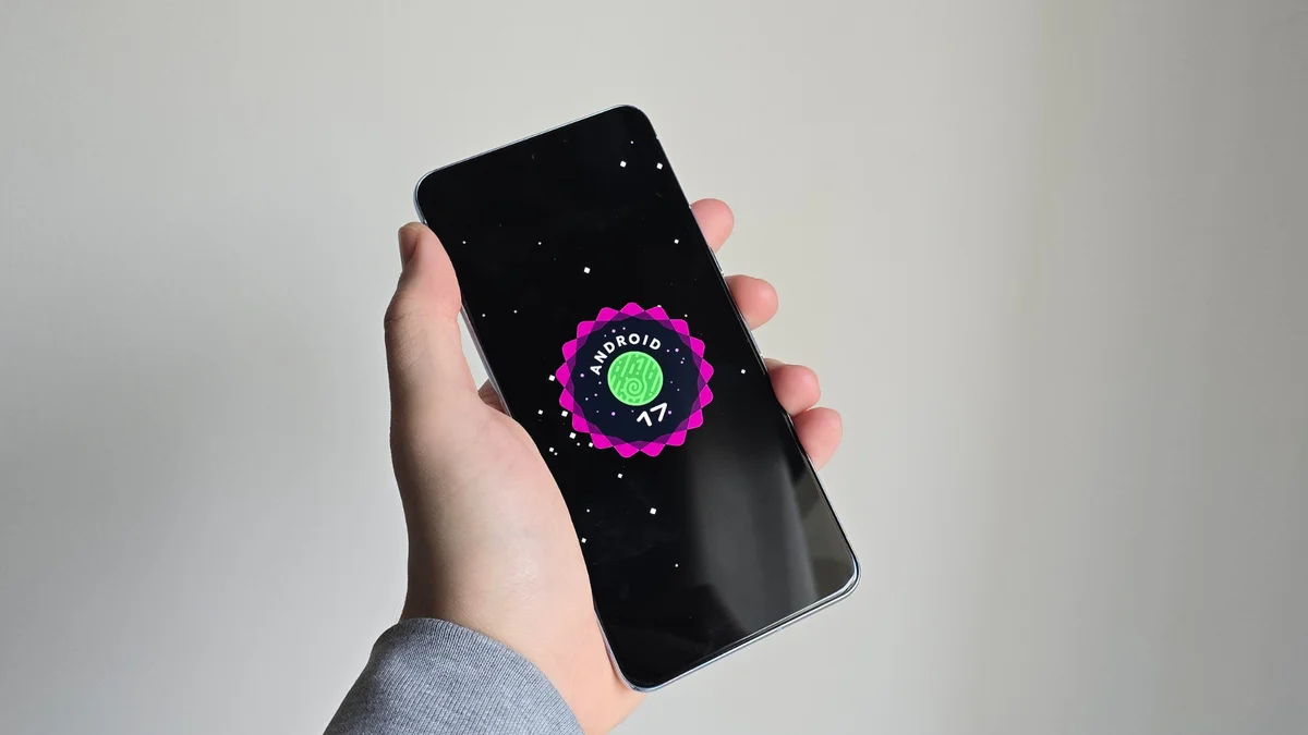 pessoa segurando celular com a logo do Android 17 na tela