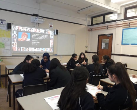 Students discuss a Black History Month quiz question shown on a classroom projector screen