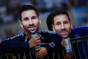 Torcedores exibem máscaras em despedida de Lionel Messi