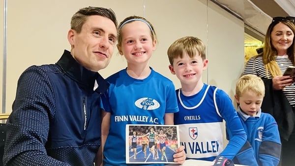 Mark English posing for a photo with children