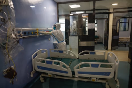 a nurse in protective gear works in a hospital room